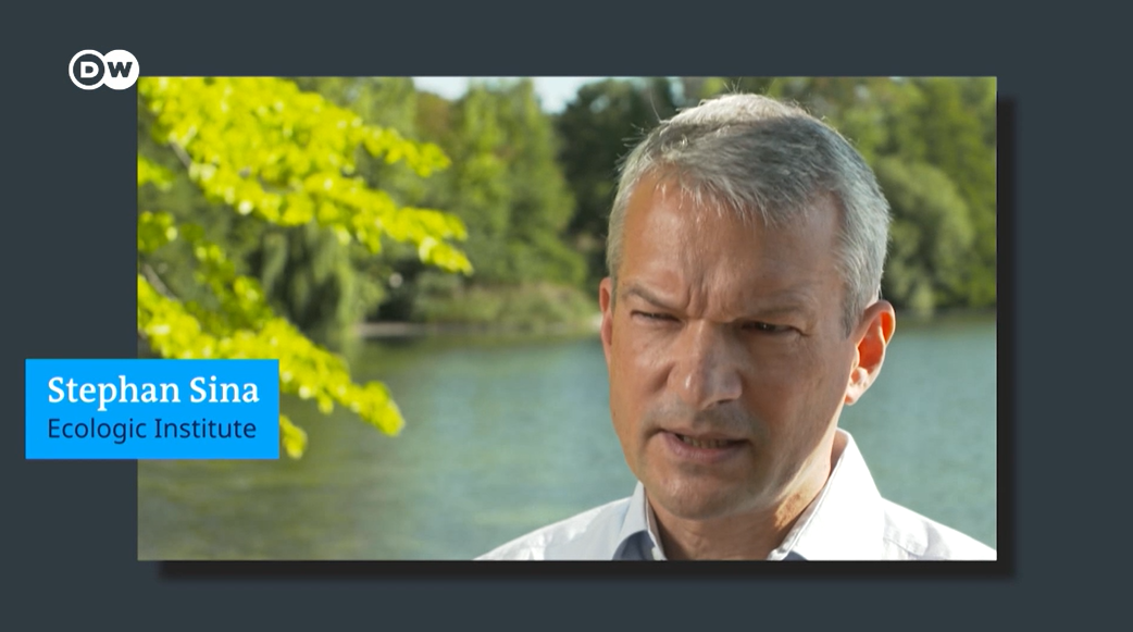 Video screenshot: Dr. Stephan Sina infront of a lake or river