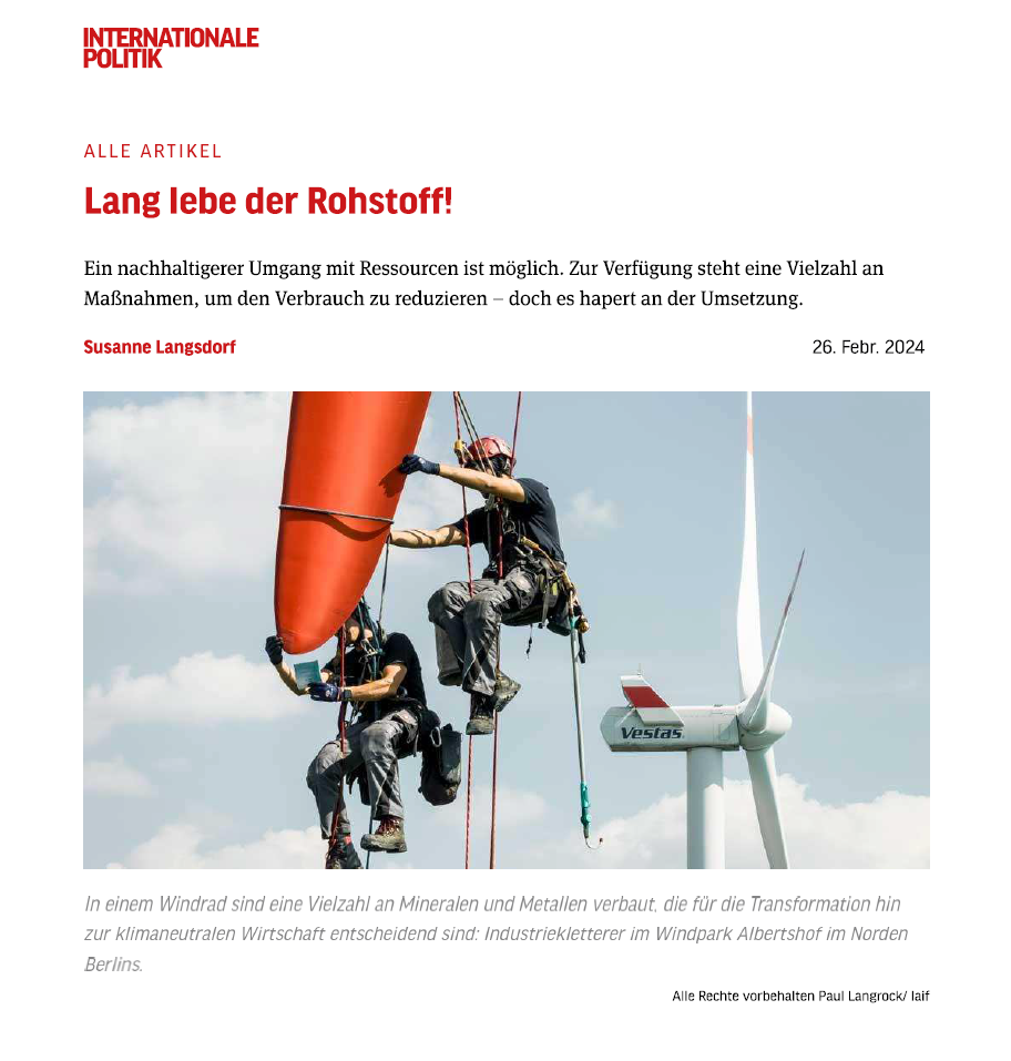 Titelkopf und Anfang des Artikels 'Lang lebe der Rohstoff!'. Ein beigefügtes Bild zeigt zwei Industriekletterer, die an einem Windrad arbeiten, im Hintergrund ist eine weitere Windturbine sichtbar. Unter dem Bild steht der Hinweis, dass Windräder eine Vielzahl an Mineralen und Metallen enthalten, die für die Transformation hin zu einer klimaneutralen Wirtschaft entscheidend sind.