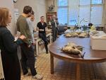 Researchers gathered around a table with animal specimens during a biodiversity research lab visit and scientific discussion.