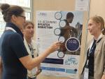 Three participants in conversation in front of a SEA4FUTURE project poster on co-designing bycatch reduction and adaptive fisheries management in the Mediterranean Sea.
